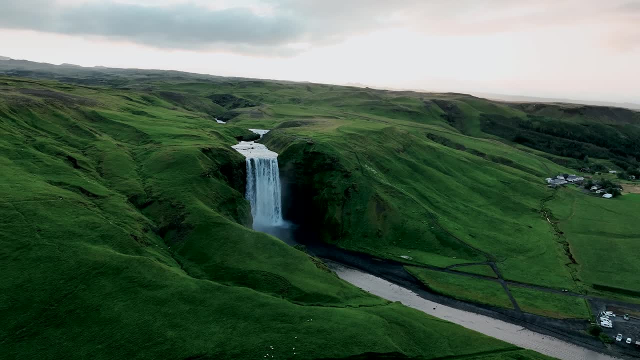 la cascada de skogafoss rodeada de un paisaje exuberante en verano en islandia - toma aérea de un dron