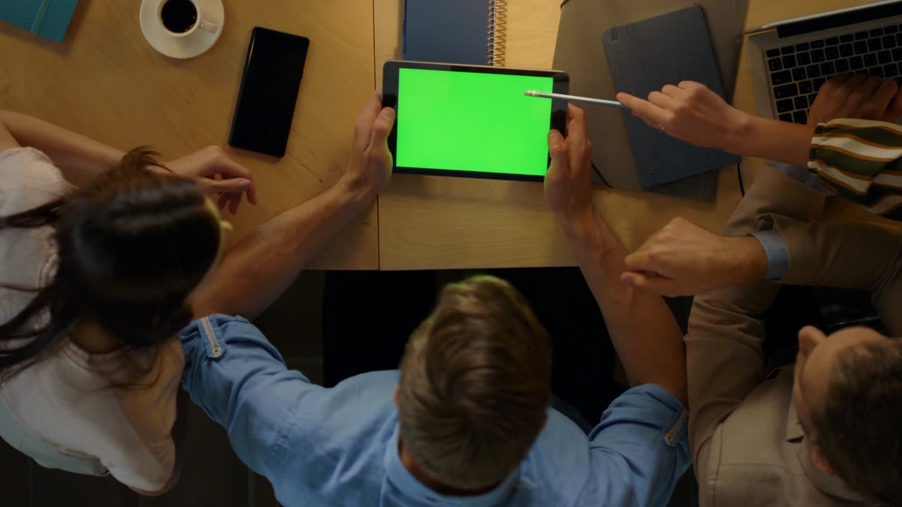 Man sitting table with colleagues. Entrepreneurs looking green screen tablet.