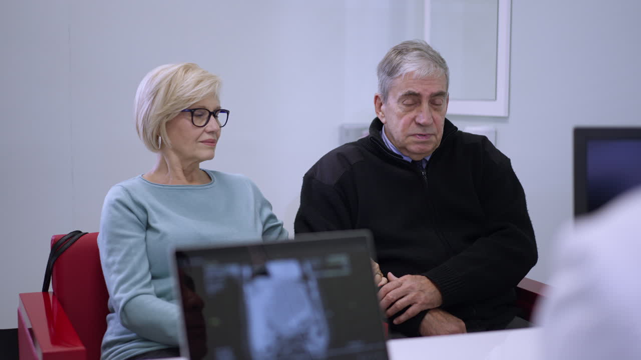 Elderly couple consulting with doctor looking at sonogram