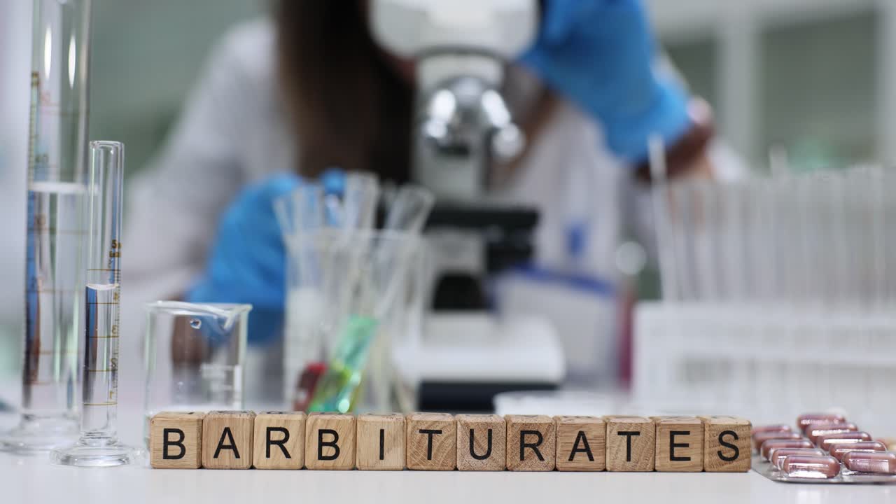 Laboratory specialist studies barbiturates through microscope