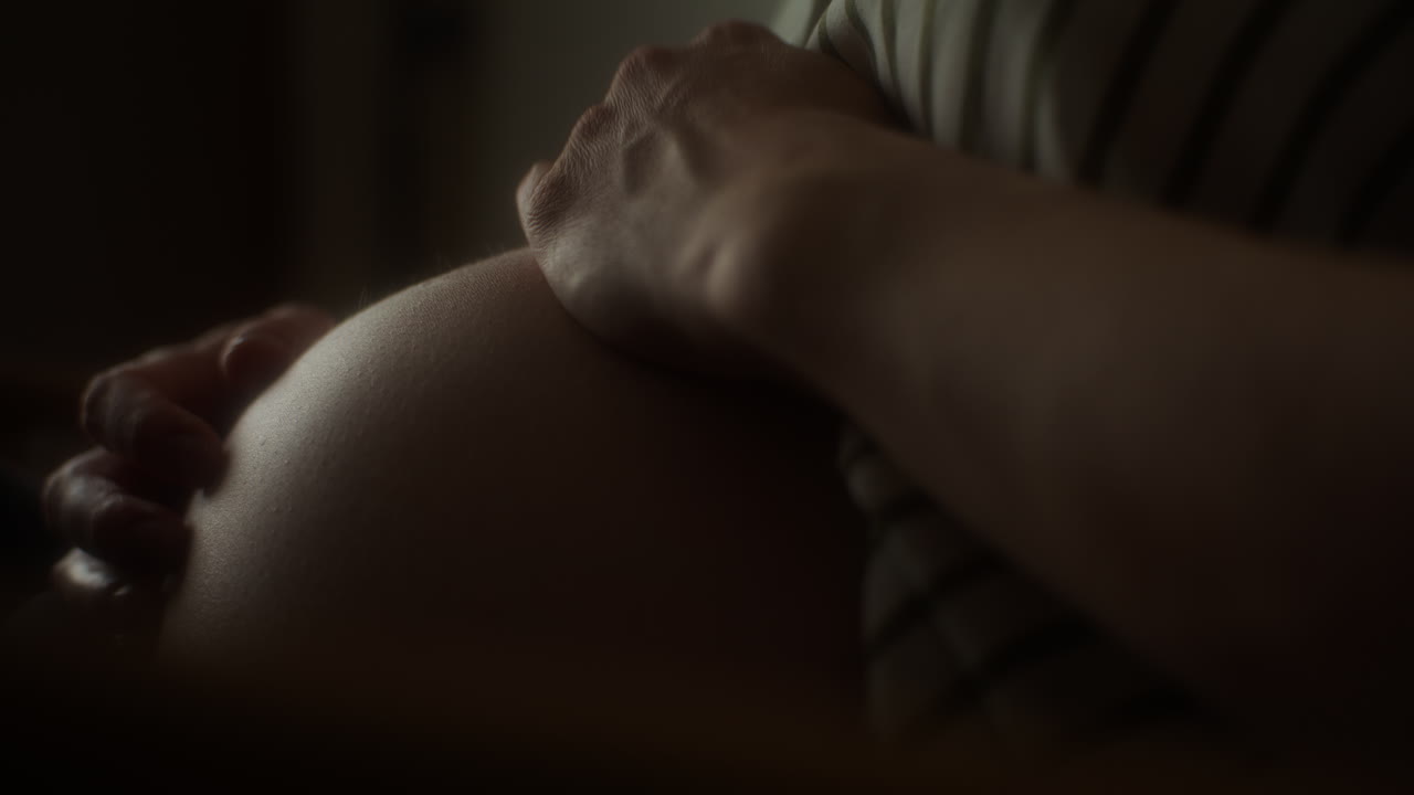 una mujer embarazada se frota el vientre.