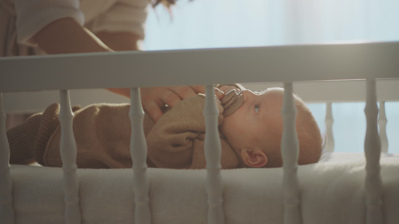 Madre che accudisce il neonato nella culla