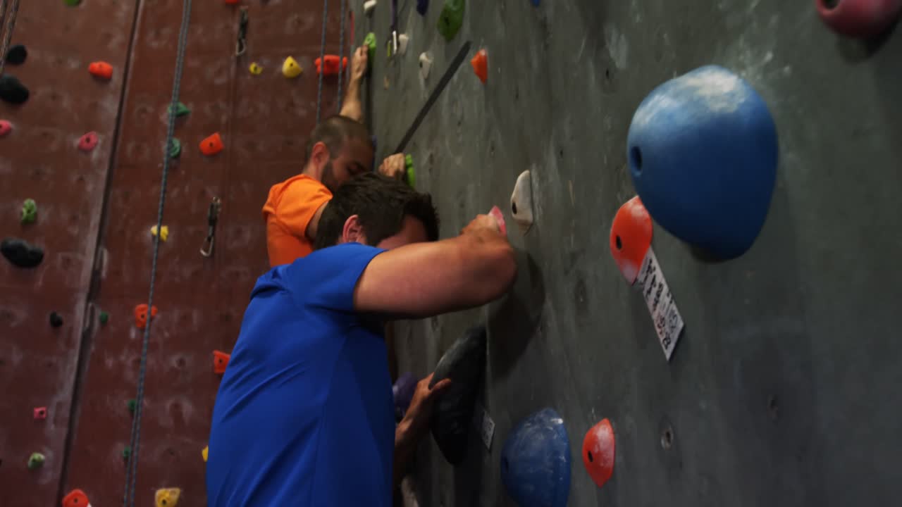 hombres y mujeres escalando la pared artificial 4k