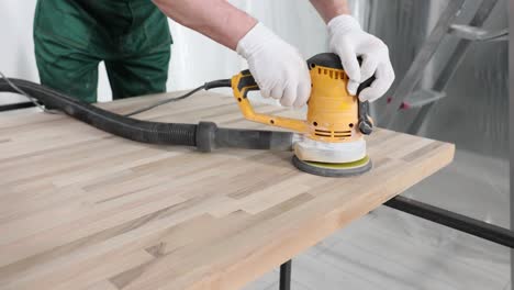 sanding a wooden surface with an orbital sander