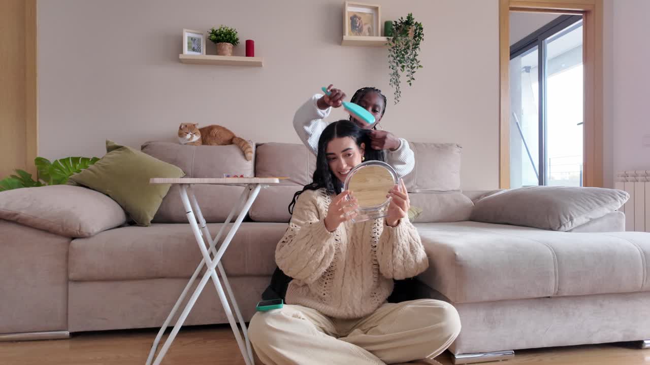 Women braiding hair indoors