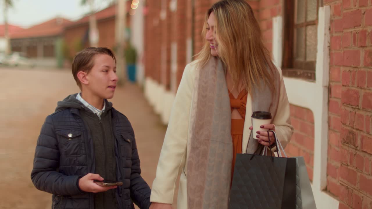 Mother and son walking and shopping on the street