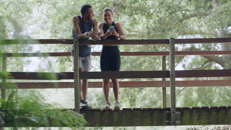 Active-couple-resting-on-a-bridge-after-exercising