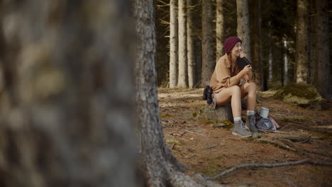 female explorer sitting with diary on tree stump