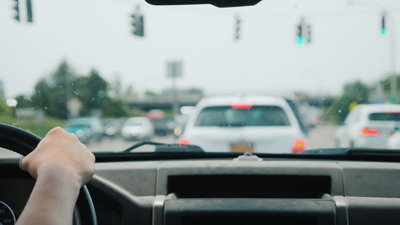 운전자는 운전대와 교통 혼잡에 손을 얹은 프레임에 교통 체증이 있습니다.