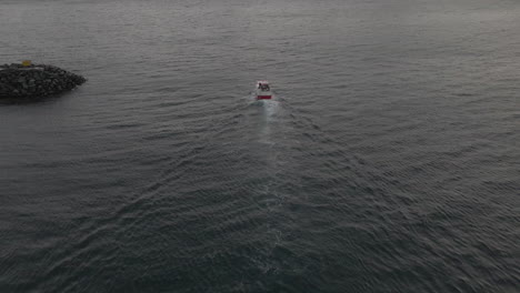 commercial fishing vessel exits safety of harbour into the open arctic ocean, drone