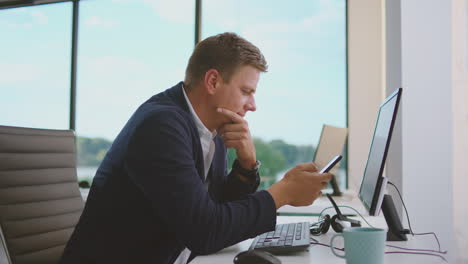 businessman looking at his phone in the office