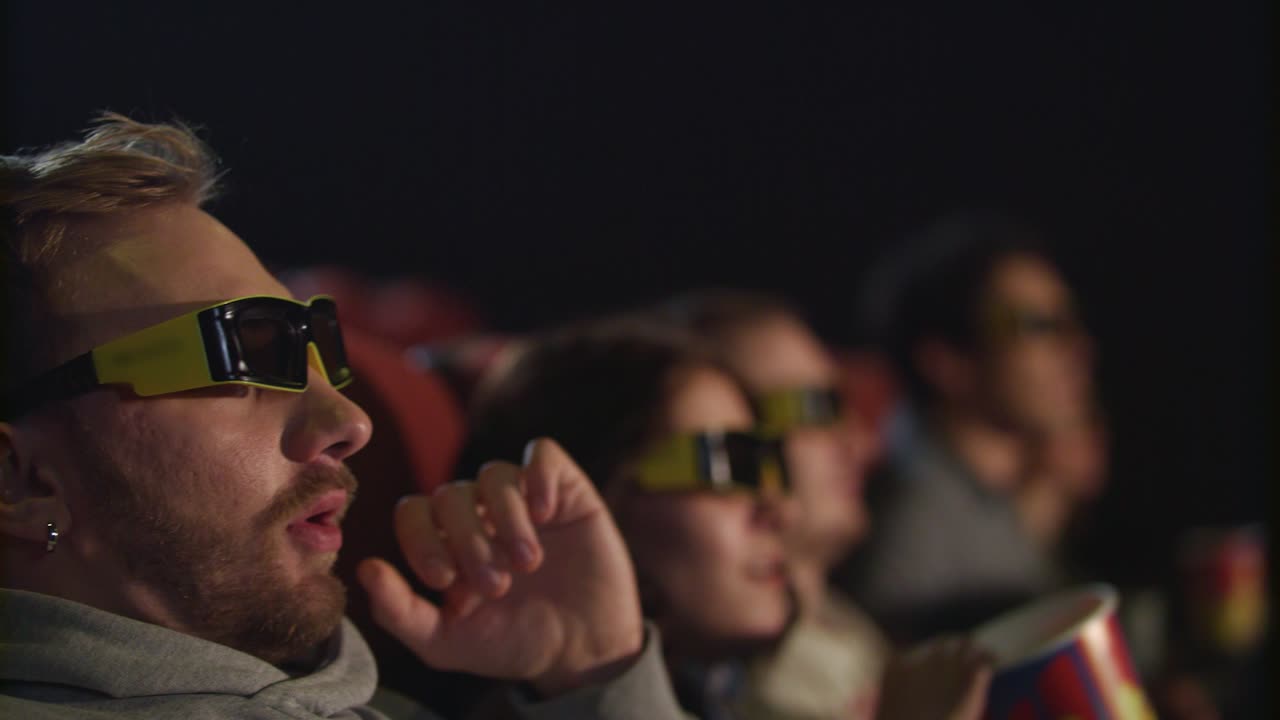 hombre quitarse las gafas de cine en el cine en cámara lenta. cansado de la película 3d
