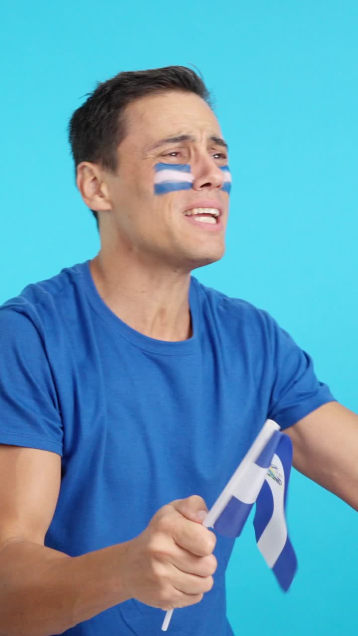 Nervous man cheering for El Salvador during a match looking away