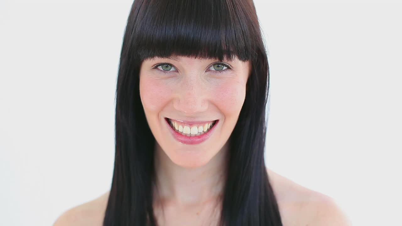 Smiling brunette woman flossing her teeth