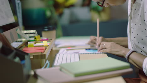 mujer de negocios que trabaja hasta tarde escribiendo notas usando computadora información de investigación en línea planificación de datos plazo de proyecto estrategia en la oficina por la noche usando auriculares