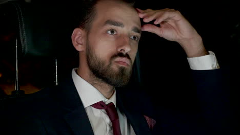 hombre de negocios enfocado trabajando en una computadora portátil en el asiento trasero de su limusina con conductor personal
