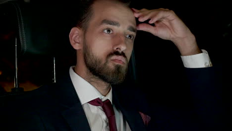 focused businessman working on laptop in the back seat of his limousine with personal driver