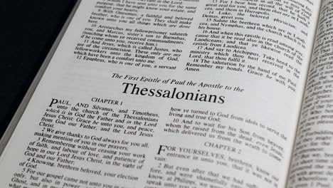 close up shot of bible page turning to the book of first thessalonians