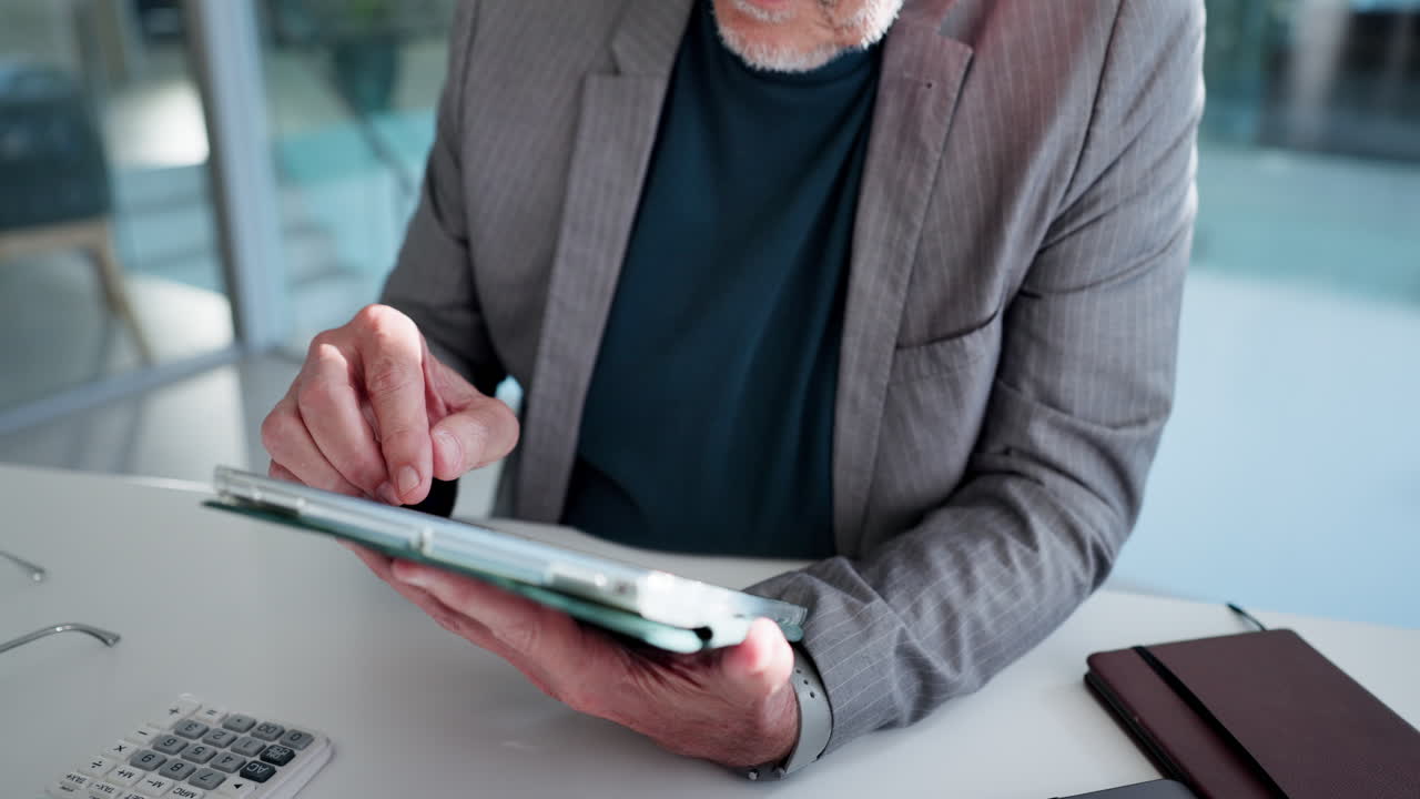 Uomo d'affari anziano che usa un tablet digitale in un ufficio moderno