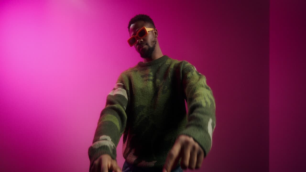 hombre elegante en suéter de camuflaje con gafas de sol amarillas