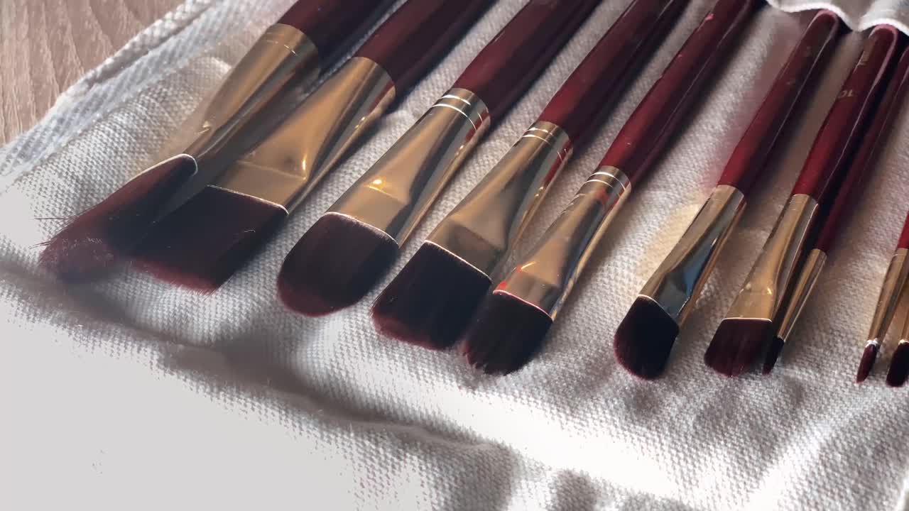 Set of different clean paint brushes in a white fabric case