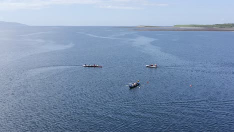 drone orbit around galway bay ocean currents as currach rowing boats move through water