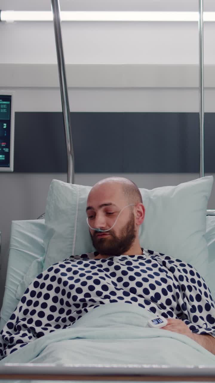 Vertical video: Patient discussing with doctors while resting in bed during medical recovery