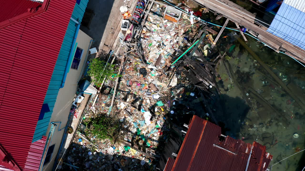 imágenes de drones aéreos verticales de arriba hacia abajo que muestran una contaminación plástica masiva en un pueblo flotante en camboya