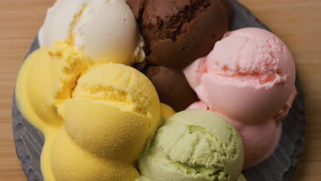 assorted scoops of ice cream melting on a plate