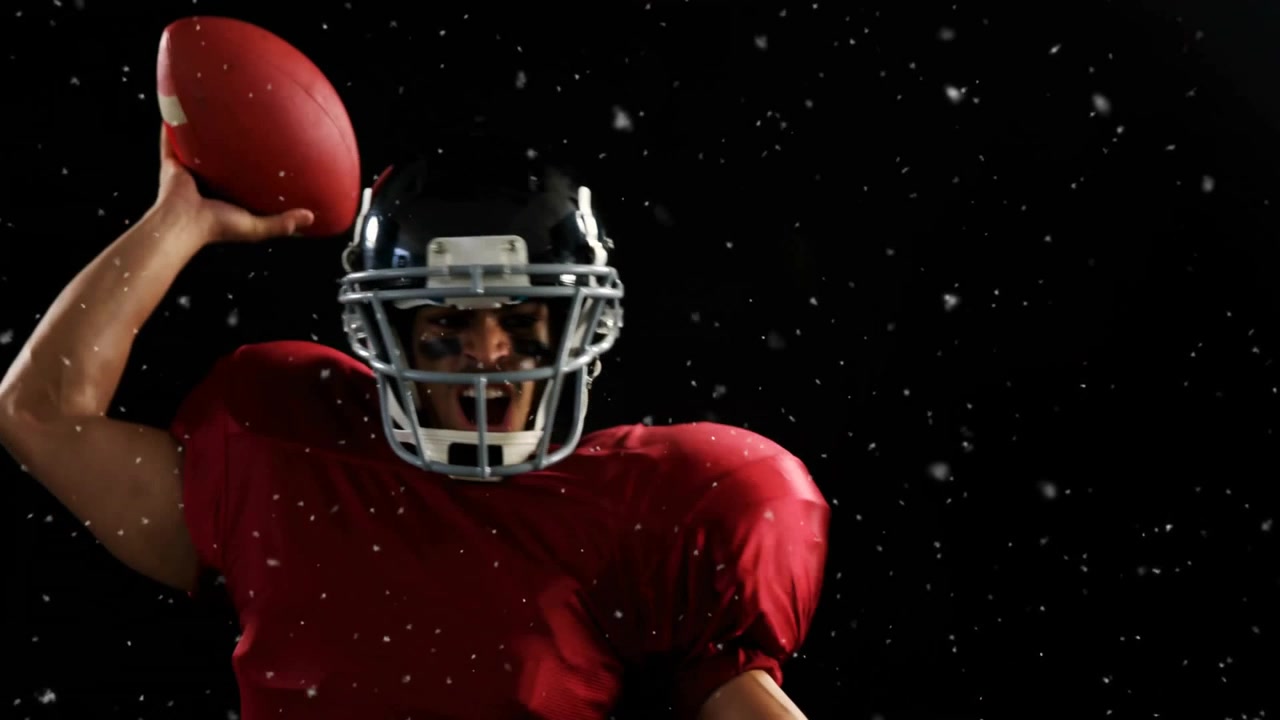 Giocatore di football americano con casco che emerge dal buio, scruta e afferra il pallone, potenziando il lancio con la nebbia.
