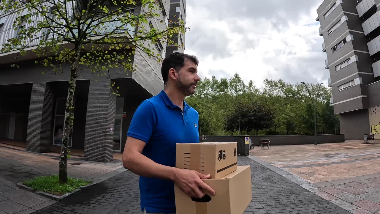 Man carrying boxes outside a building