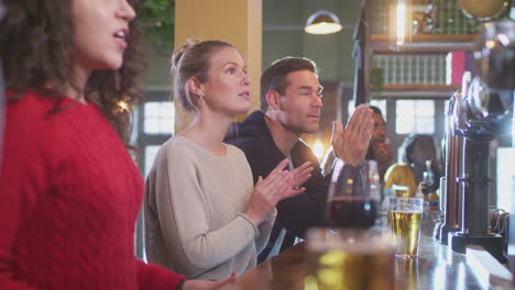 Grupo-De-Clientes-Decepcionados-En-Un-Bar-Deportivo-Viendo-Un-Evento-Deportivo-En-Televisión-Mientras-El-Equipo-Pierde