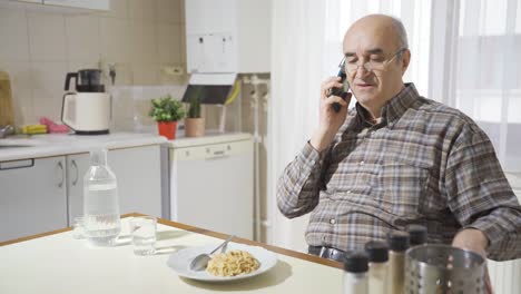 Alter-Mann-Telefoniert-In-Der-Küche.