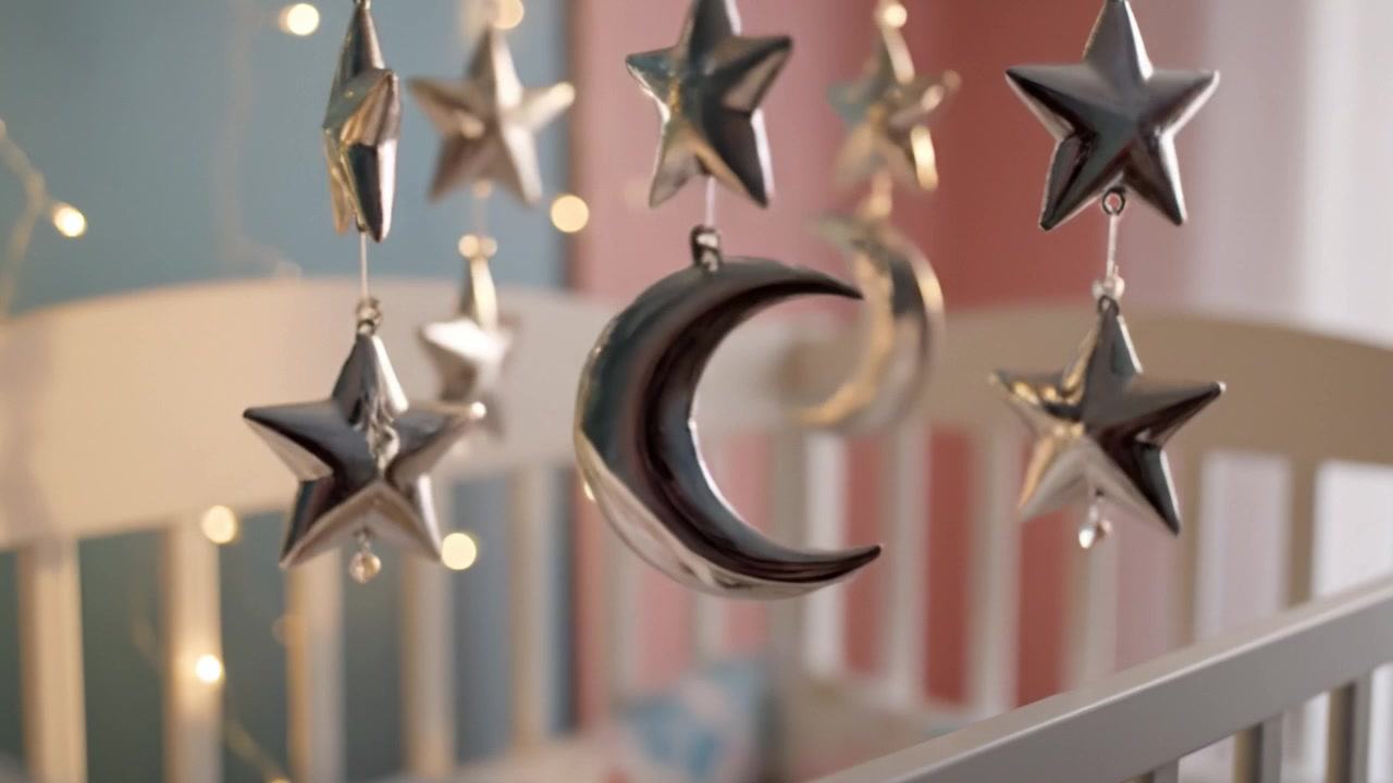 Charming Baby Mobile with Silver Stars and Moons Hanging Over Crib in a Softly Lit Nursery