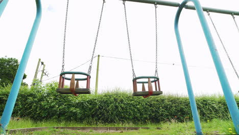 Verlassener-Spielplatz-Mit-Leeren-Schaukeln,-Die-Sich-Während-Der-Coronavirus-Pandemie-In-England-Im-Wind-Wiegen