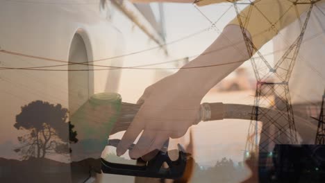 animation of electricity poles over hands of caucasian woman refueling car