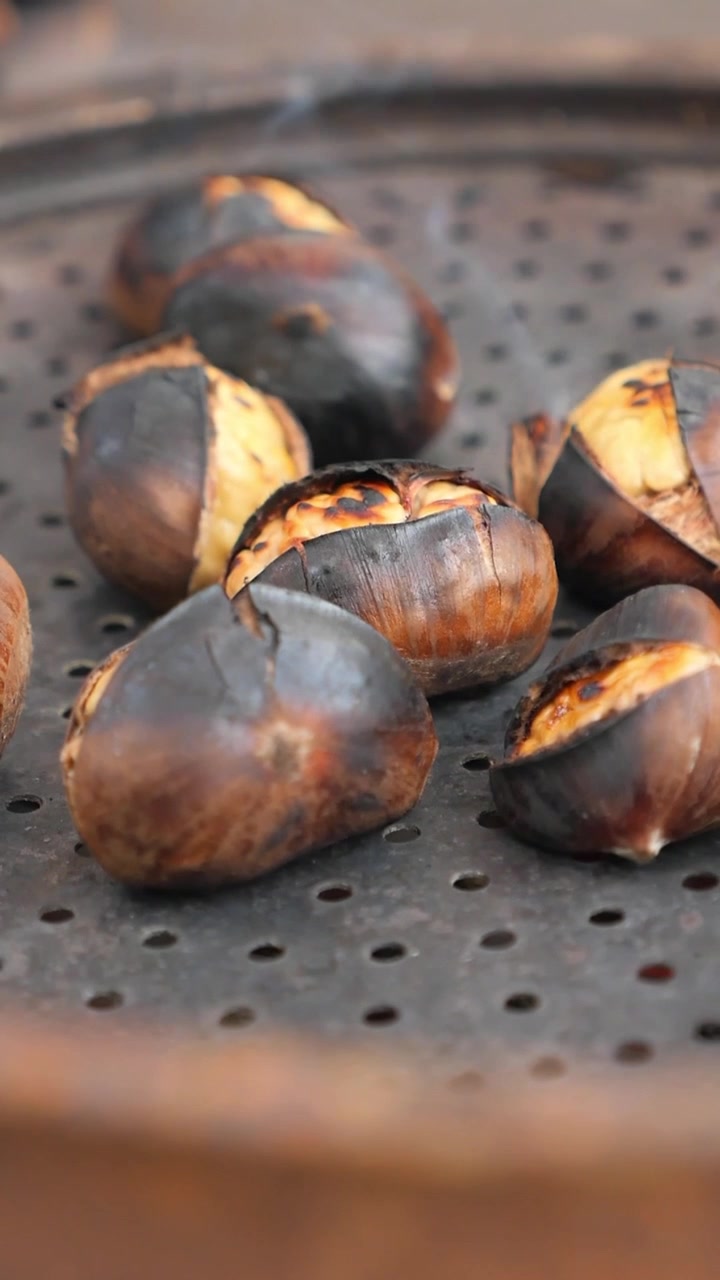Hot Roasted Chestnuts Steaming on a Perforated Pan