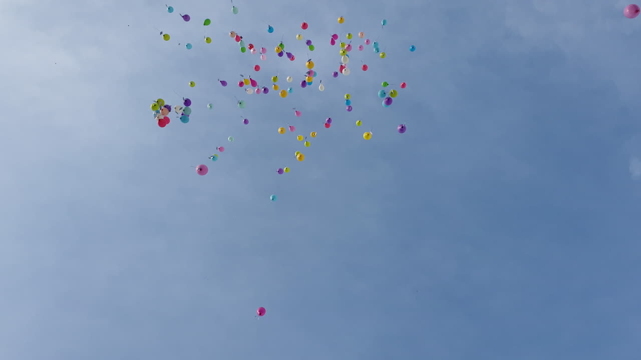 다채로운 풍선이 오후 하늘로 날아간다