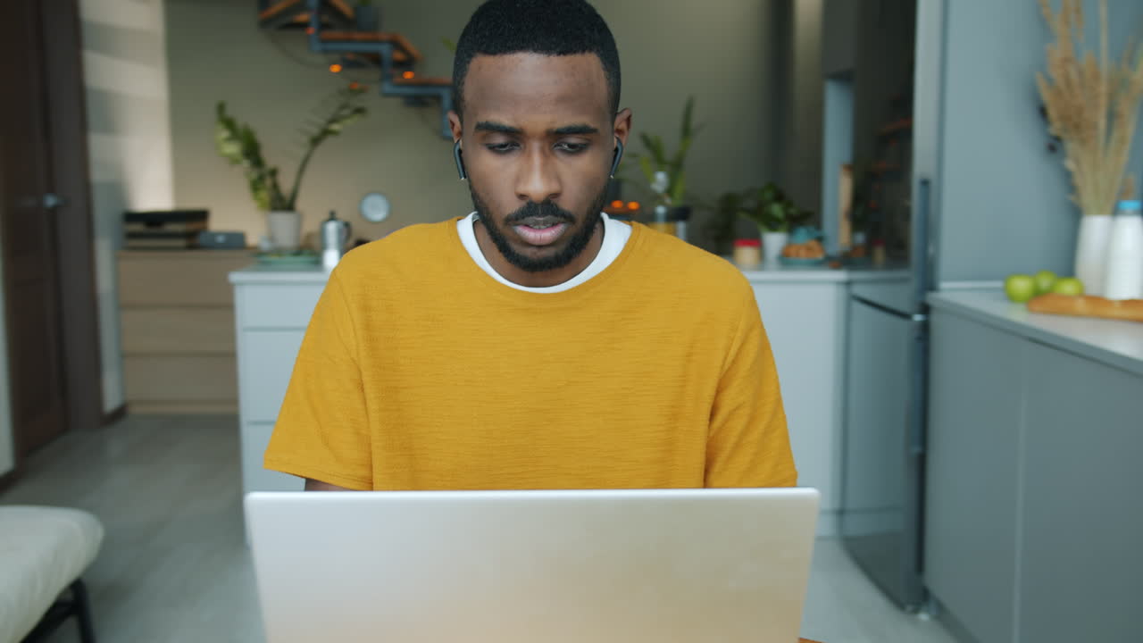 hombre trabajando en una computadora portátil en la cocina