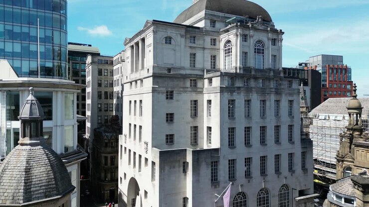 Aerial drone flight slowly rising to the rooftop of the Gotham Hotel in Manchester City Centre showing off some Gothic architechture and modern apartments