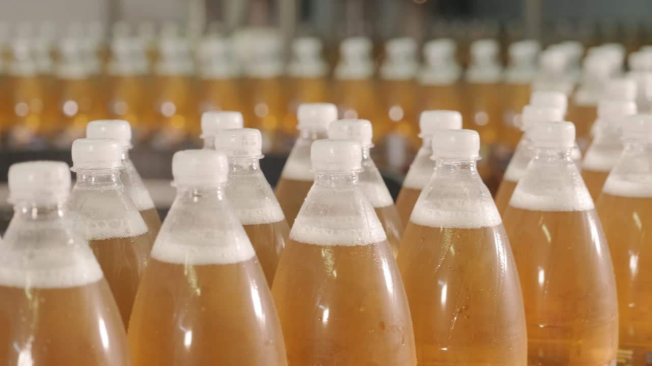 현대 음료 공장에서 주스 또는 물을위한 병을 가진 컨베이어 벨트 - 달한 소다 물의 현대 생산