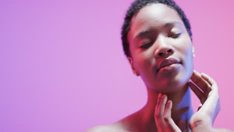 african american woman with short dark hair in blue and pink light with copy space, slow motion