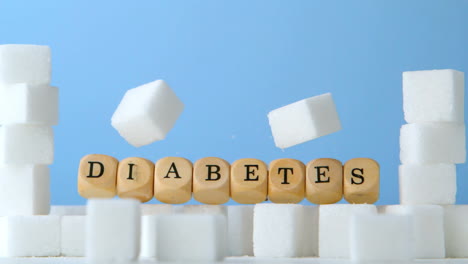 Dice-spelling-out-diabetes-falling-over-sugar-cubes-in-blue-background