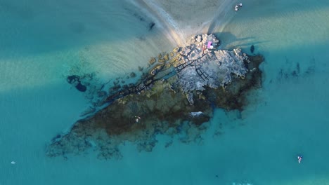 Ovehead-clip-over-an-exotic-beach-and-rock-formation-in-Calpe,-spain-on-a-clear-summer-day