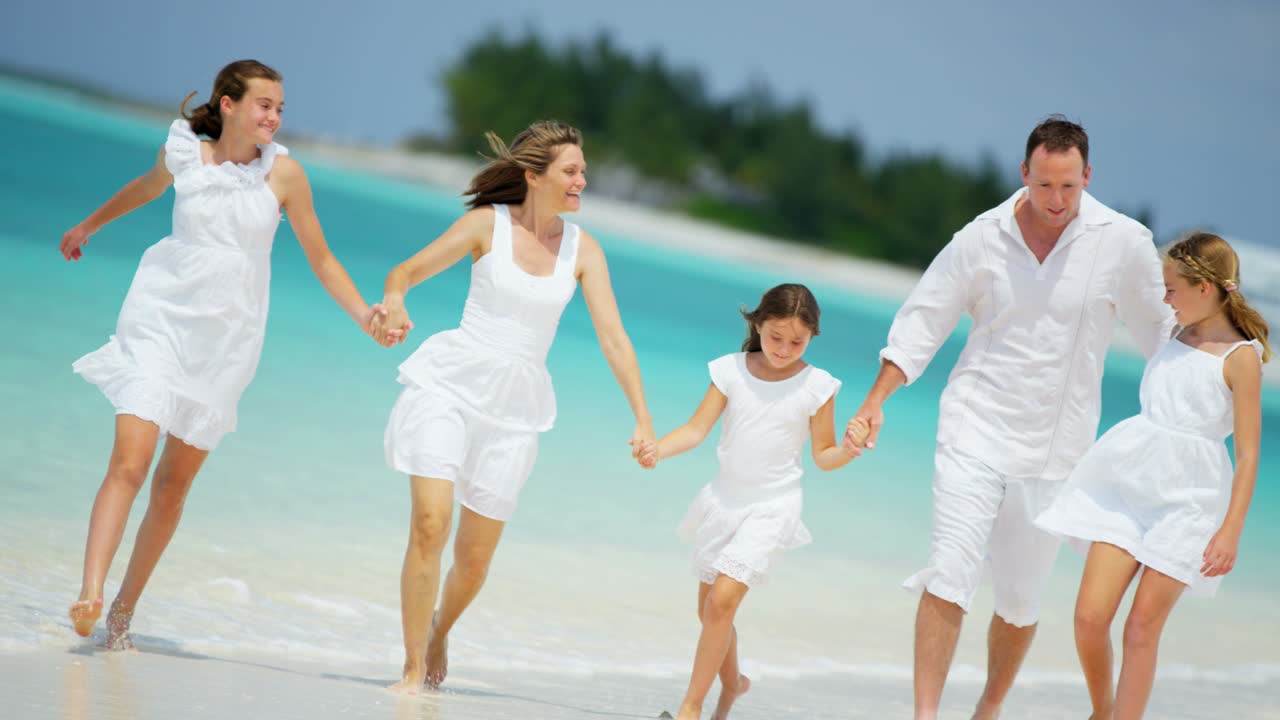 사랑하는 백인 가족이 열대 해변에서 재미를 느끼고 있습니다.