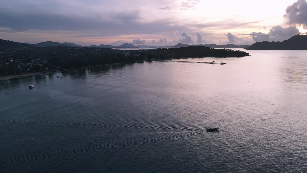 antena de drones sobre tailandia durante el amanecer con barco conduciendo en el océano paralaje con nubes