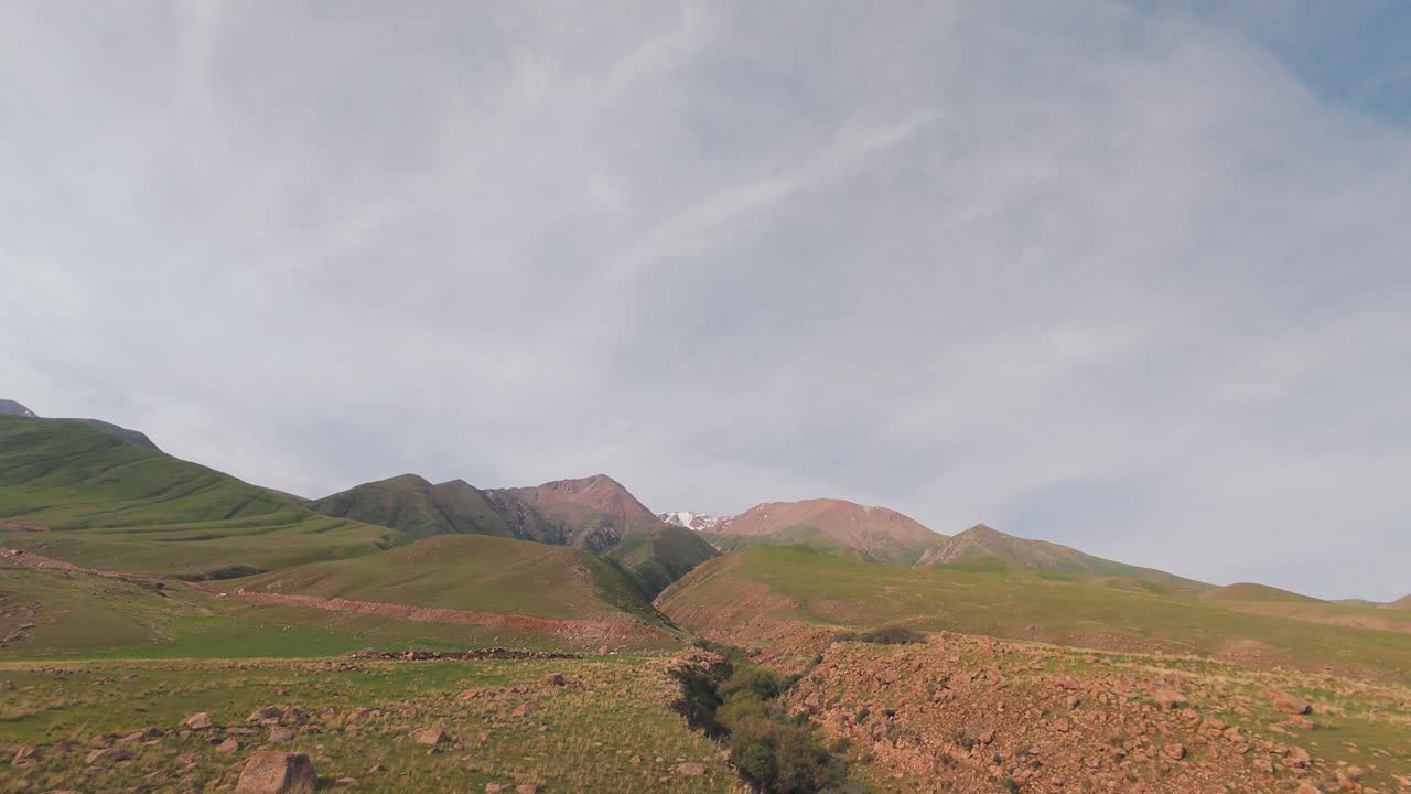 Gare di droni FPV sopra i prati verdeggianti, le anse dei fiumi e le pinete di Arashan che si snodano nella luce delle montagne kirghise