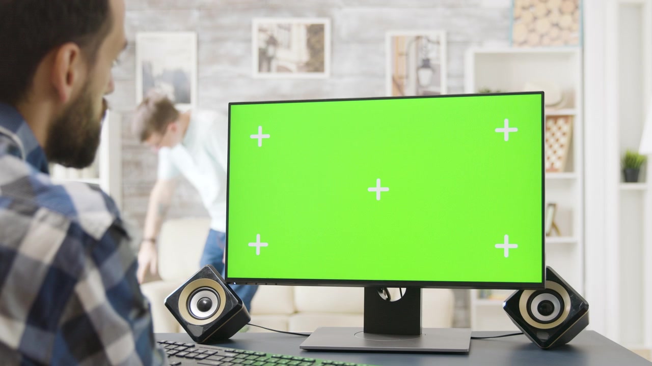 Man Working on Computer with Green Screen Monitor in Home Office
