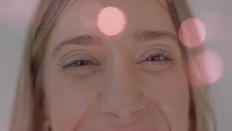 close-up of smiling woman with bokeh lights animation over her face