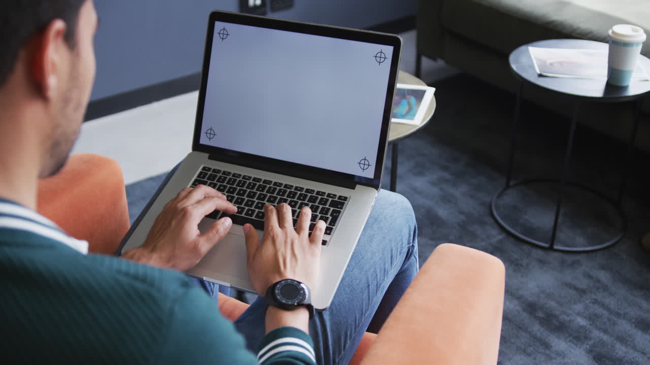 Biracial businessman sitting using a laptop in a modern office